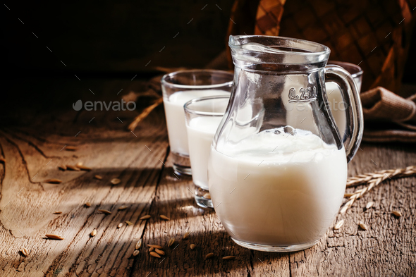 Fresh cow's milk in glass jug, vintage wooden background, still life in  rustic style Stock Photo by 5PH