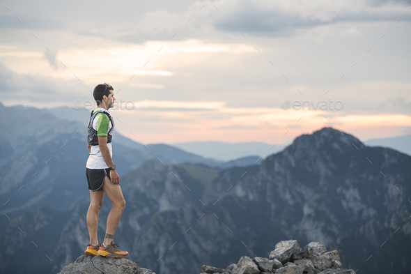 mountain running man standing on trail looking at sunset - Stock Photo - Images