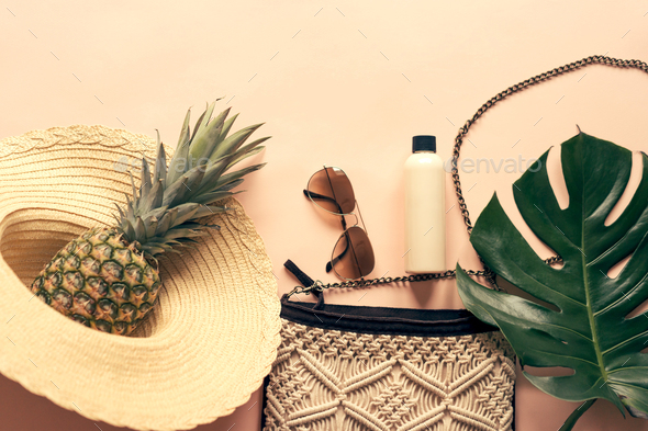 Summer flat lay set with the necessary things for a beach holiday, a handbag on a chain, sunblock