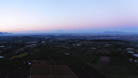 Aerial drone, dusk sunrise over farm land, ponds, dams and vineyards, light blue, pink and purple sk alt
