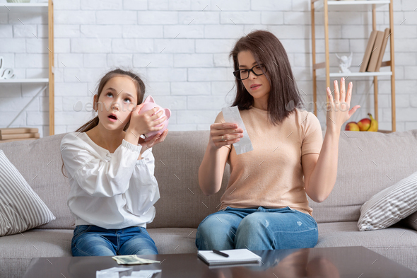 Financial crisis during coronavirus. Teen girl with empty piggy bank and mother with no money to pay