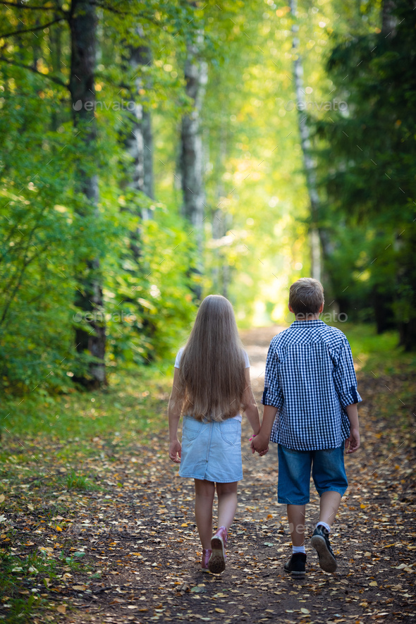 Beautiful boy and girl walking in the beautiful summer forest Stock ...