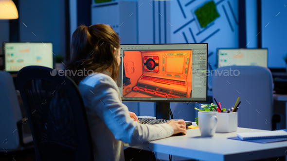 Woman game sotware developer testing new game overtime at night