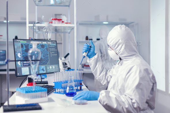 Laborant working with automatic pipette and test tubes - Stock Photo - Images