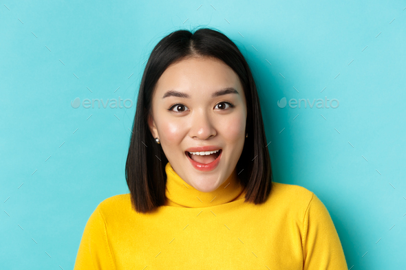 Beauty and skincare concept. Close up of surprised asian female raising eyebrows and look amused at