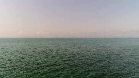 Calm Turquoise Sea and Sky with White Clouds in Sunny Day Aerial View alt