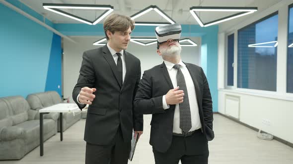 Young Elegant Handsome Caucasian Real Estate Agent Talking to Middle Aged Wealthy Client in VR alt