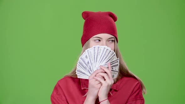 Teen Is Holding Paper Money in Her Hands. Green Screen. Slow Motion alt