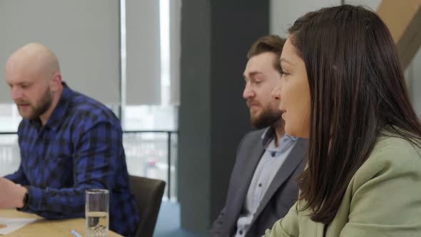 Group of Business Workers Sitting on Desk Using Laptop Reading Documents at the Office alt