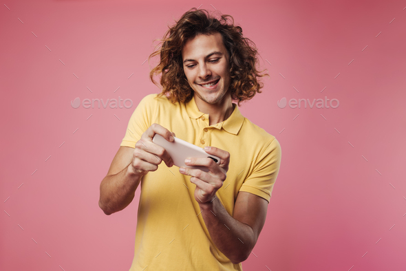 Happy handsome guy playing online game on mobile phone