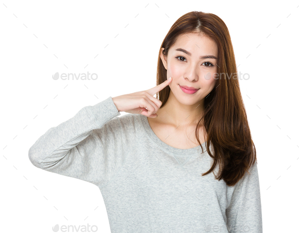 Asian woman with finger point to her dimples