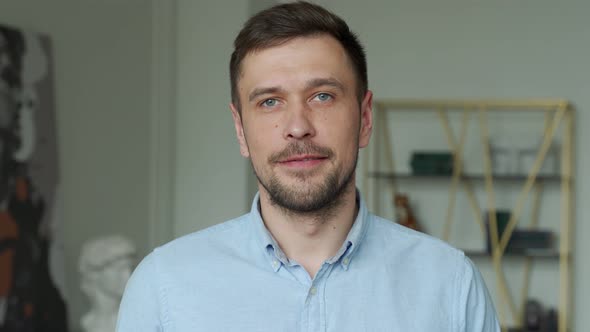 Portrait of a Young Handsome Man in a Shirt Smiling at the Camera alt