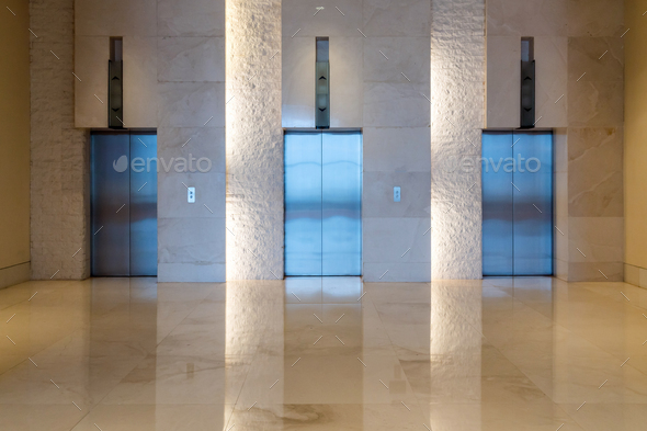 Three elevator doors interior building with low light