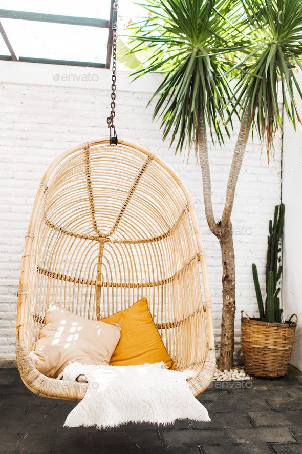 Wicker rattan hanging chair in loft cafe. Eco friendly furniture style and concept