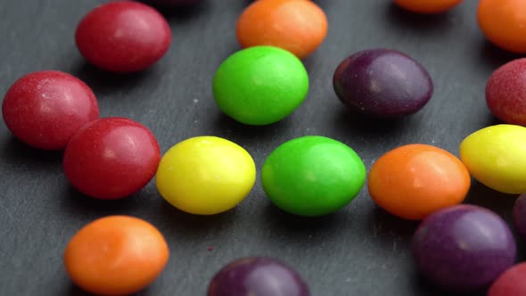 Colored Fruit Candies Rotate on a Black Background Colored Marco Sweets alt
