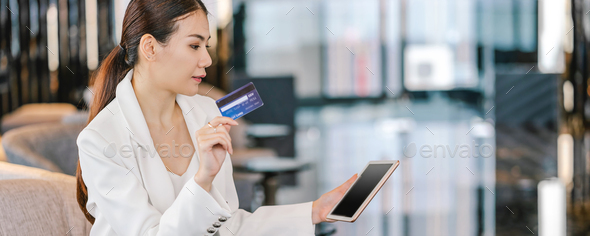 Banner, web page or cover template of Portrait Asian woman using credit card with technology tablet