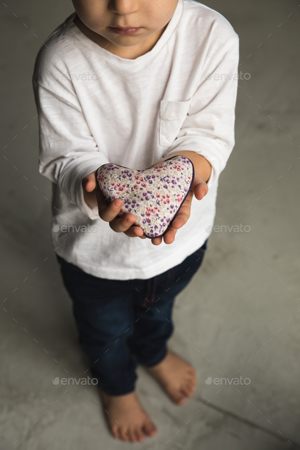 Baby boy hands giving toy heart. - Stock Photo - Images