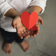 Two baby hands holding red paper hearts. - PhotoDune Item for Sale