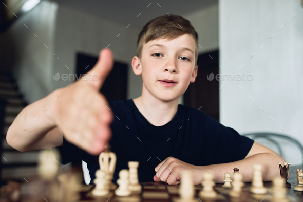 A boy plays chess at home during quarantine. Leisure, Hobbies.