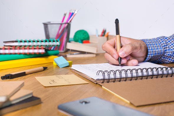 Young man sitting at the table and studying from home - Stock Photo - Images