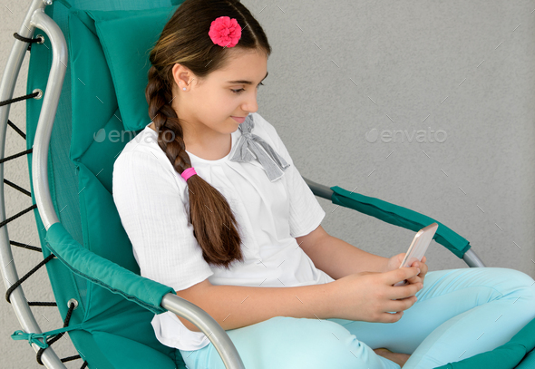 Young girl texting a message on her mobile - Stock Photo - Images
