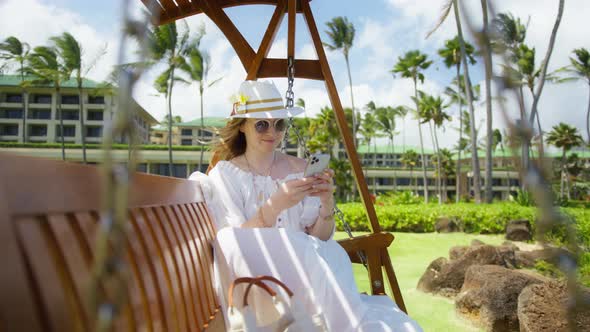 Woman in Boho Style Dress Travel Blogger Using Smartphone Post on Social Media alt