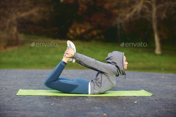 A brunette girl in a tracksuit performs morning sports exercises