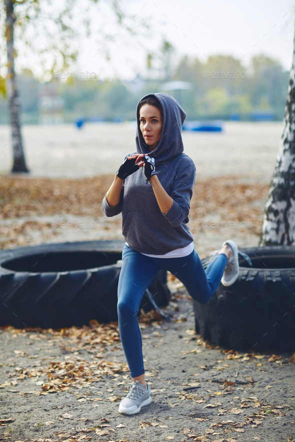 A brunette girl in a tracksuit performs morning sports exercises
