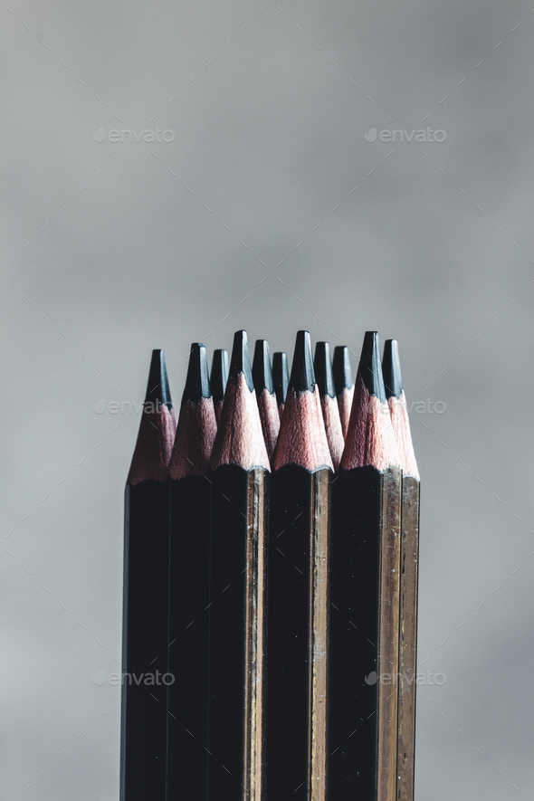 Simple graphite pencils on grey background. Black pencils, space for text  Stock Photo by serbogachuk