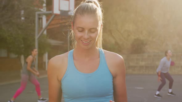 Portrait of caucasian female basketball player holding ball and looking at camera alt