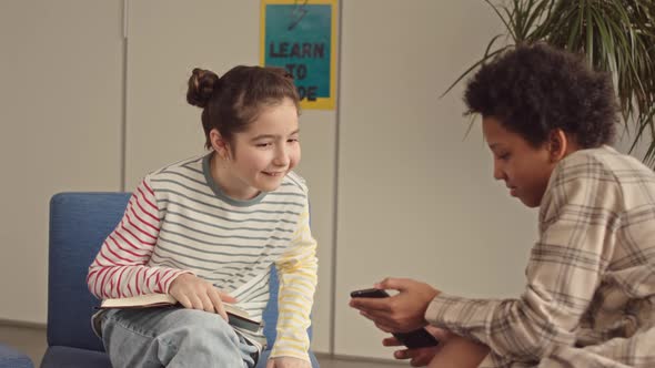 Classmates Using Smartphone during Break at School alt