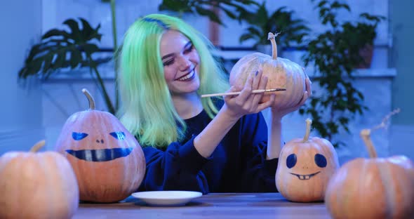  Preparation of Halloween Party, Young Teenager Girl with Scary Witch Make-up Drawing on Pumpkins 