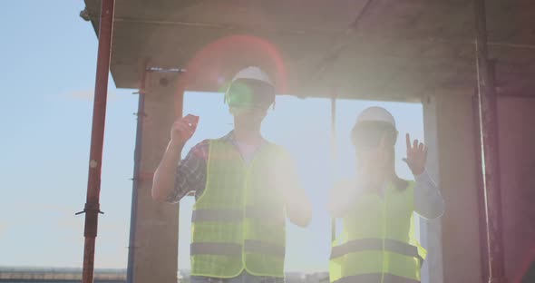 Two Contemporary Crew Workers Using VR to Visualize Projects Standing in Unfinished Building on alt