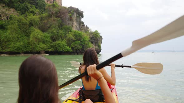 4K Young Asian woman friends kayaking together in the sea on summer vacation. alt