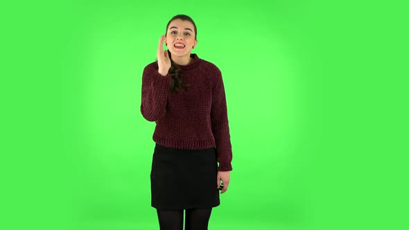Girl Screams Calling Someone on a Green Screen at Studio. Green Screen alt