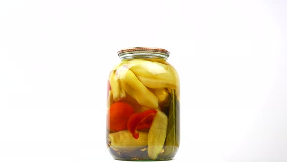 Glass jar of canned bell peppers on a white background.
