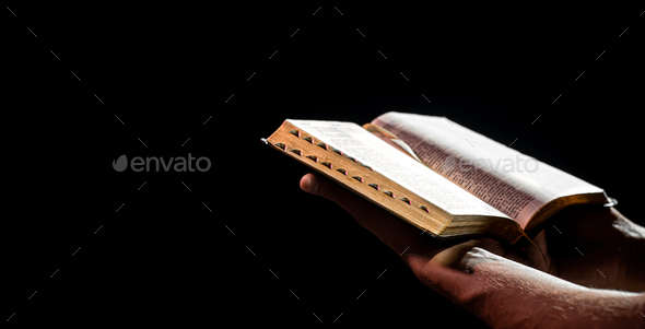 A man holds an open Bible. The concept of a relationship with God.