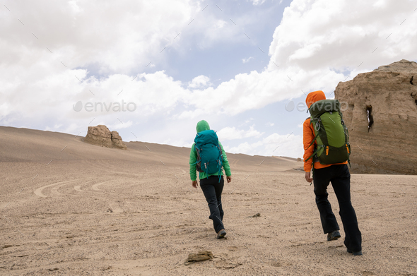Two women hikers hiking on sand desert