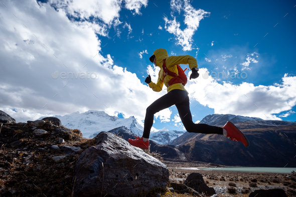 Woman cross country running in high altitude winter mountains