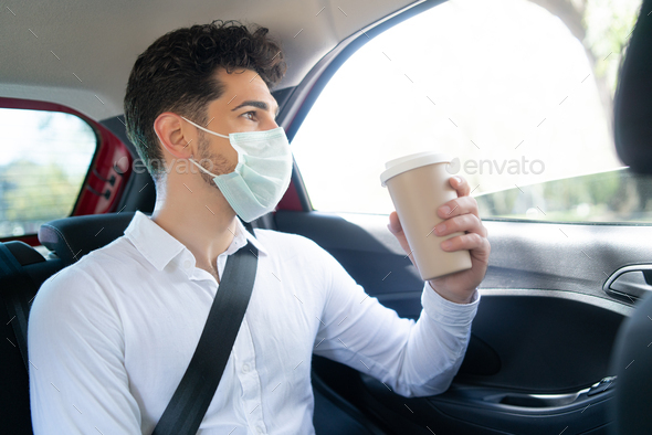 Businessman drinking coffee in car.