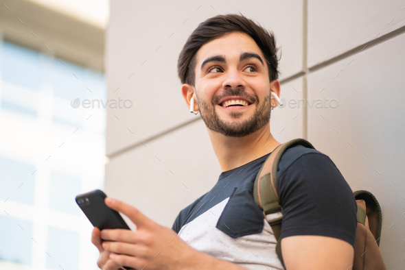 Young man using his mobile phone outdoors.