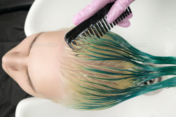 Hairdresser Holding Wet Hair in Hand and Combing Long Green Hair While  Shampooing in Shower Stock Photo by Kamchatka