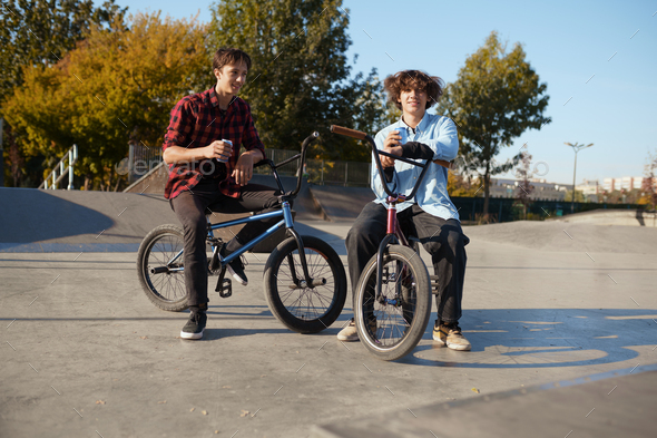 Two bmx bikers poses on ramp in skatepark