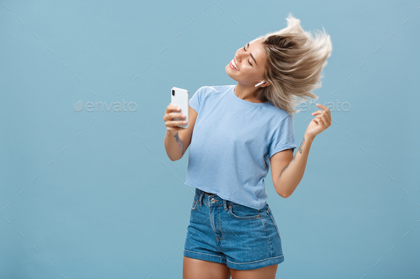 Girl enjoying cool bits in brand new wireless earphones advertising earbuds in own blog recodring