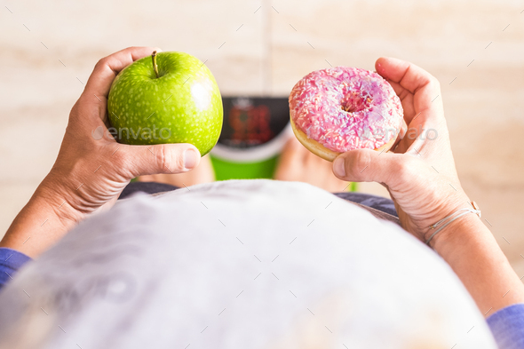 Woman Look At Donut And Apple To Select Her Nutrition Lifestyle She S On A Weight Scale Stock Photo By Perfectwave003