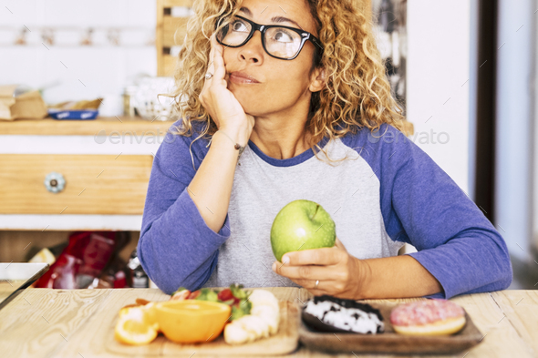woman chooise apple or donut - diet and good nutrition lifestyle, fruit and donut