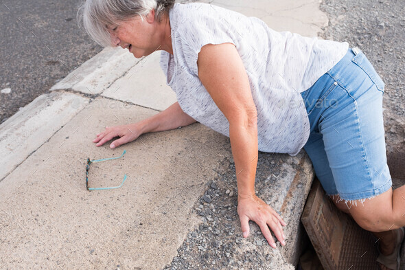 one mature woman fall in a street hole needing help - walking putting the foot inside the hole