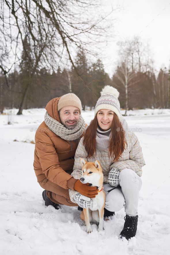 Smiling Couple Posing with Dog in Winter - Stock Photo - Images