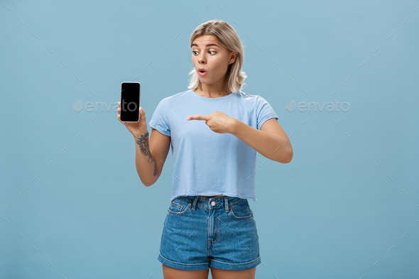 You should download app. Portrait of amazed shocked attractive blonde girl in trendy summer t-shirt