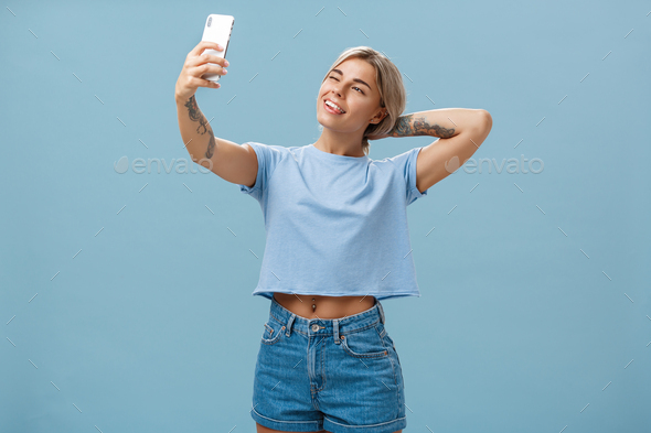 New post in my blog. Stylish feminine and sociable good-looking young female posing for selfie with